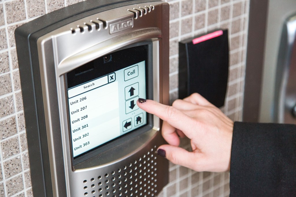 A person is pressing a button on a public telephone.