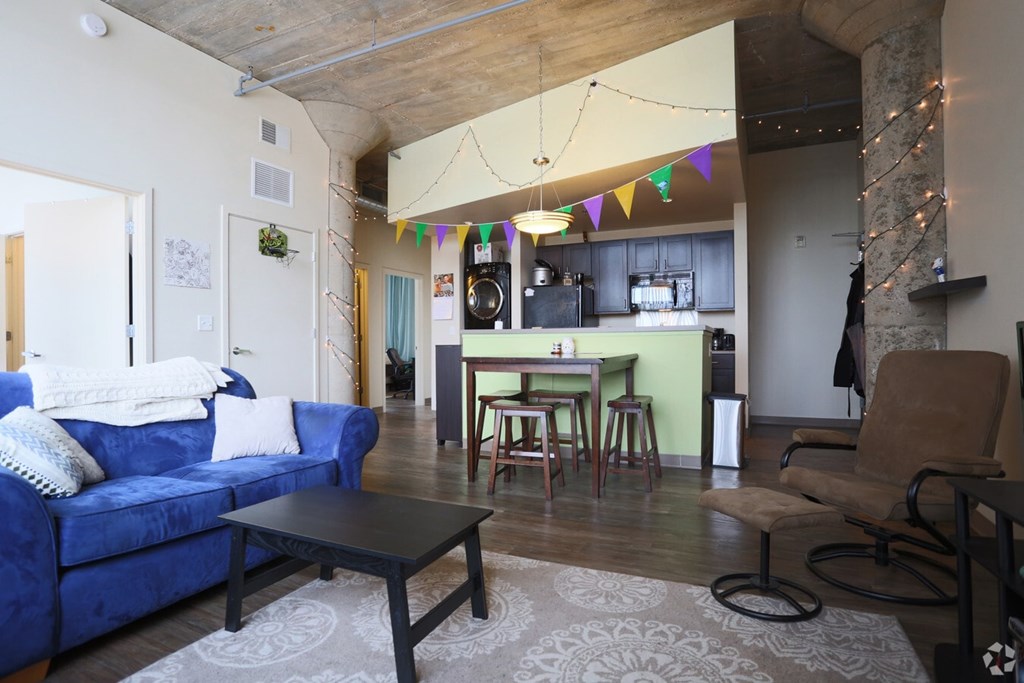 A blue couch is in the living room with a black table in front of it.