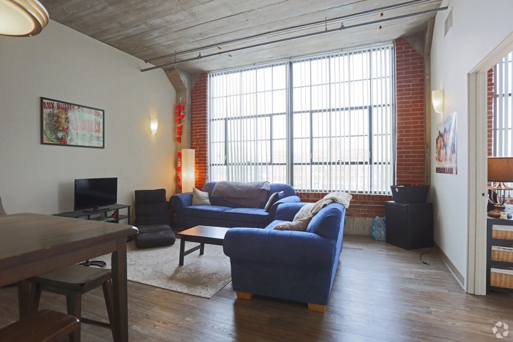 A living room with a blue couch and a wooden table.