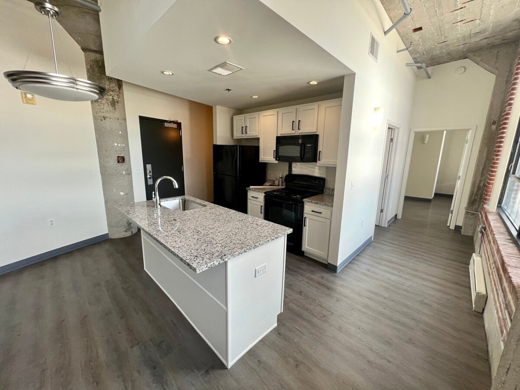 A kitchen with a granite countertop and stainless steel appliances.