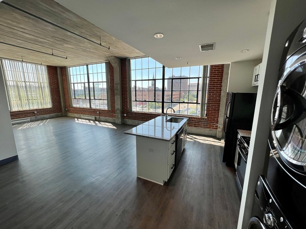 A large, empty room with wooden floors and a long table.