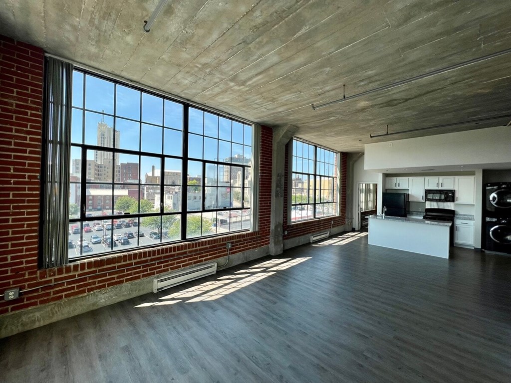 A large open space with a brick wall and a view of the city.