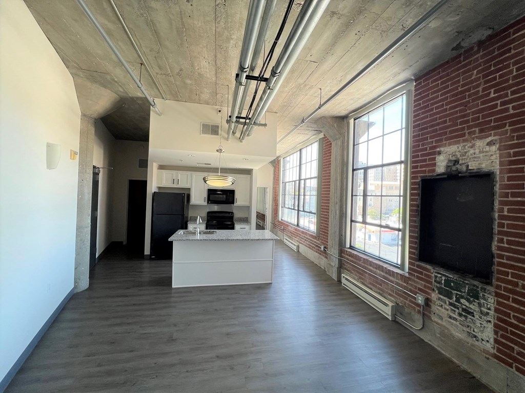 A room with a white counter and a brick wall.