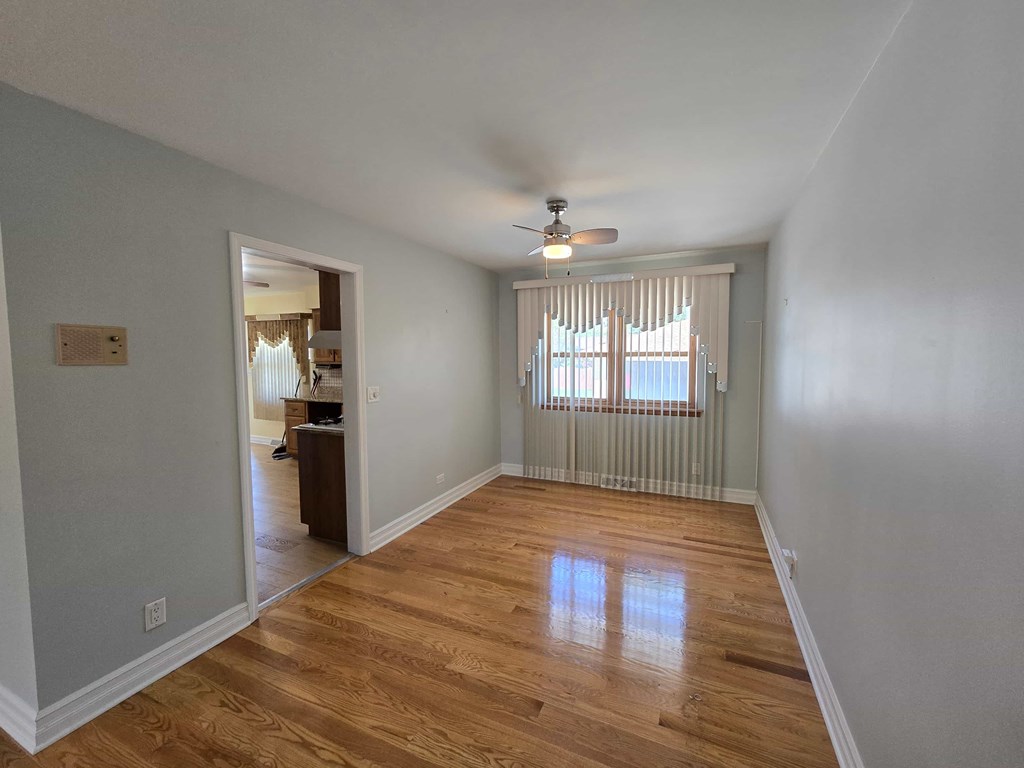 A room with wooden floors and a ceiling fan.