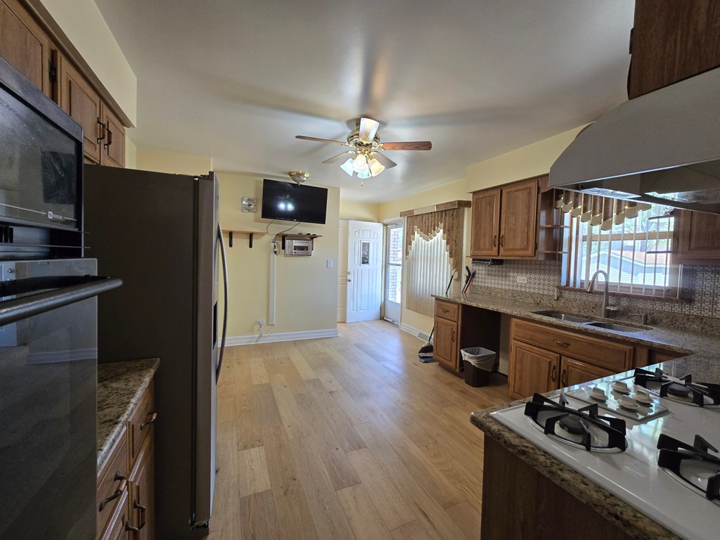A kitchen with a black refrigerator and wooden cabinets.