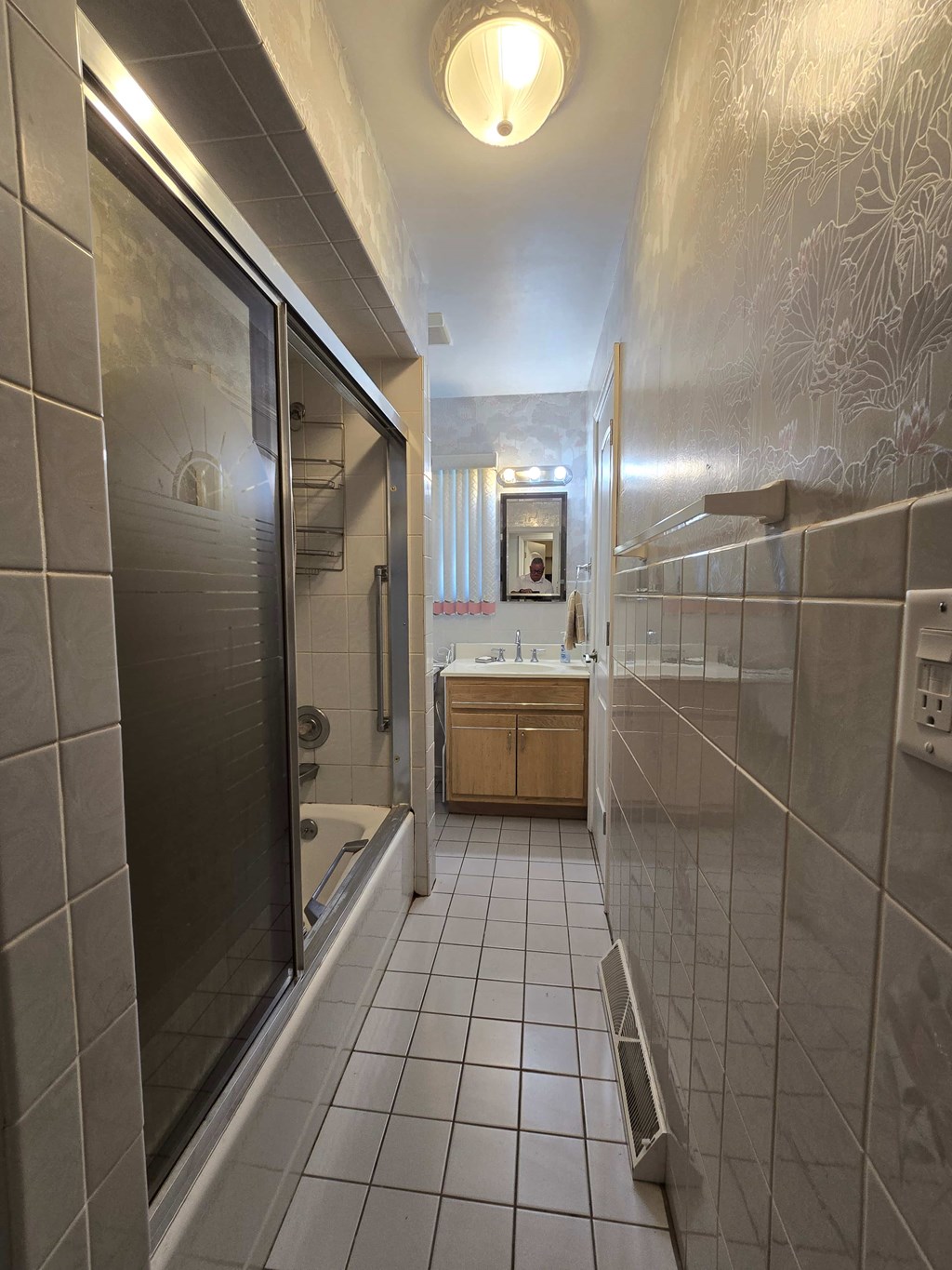 A bathroom with a walk in shower and a sink.