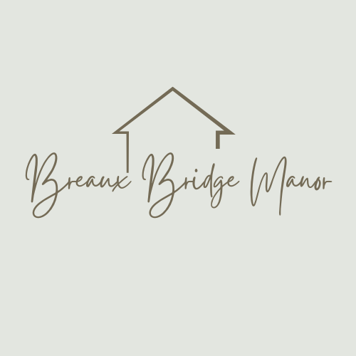 A logo with a house and the words "Breaux Bridge Manor" written underneath it.
