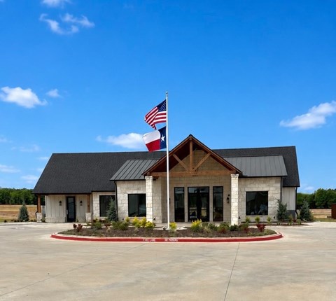 A building with a black roof and a Texas flag on top.