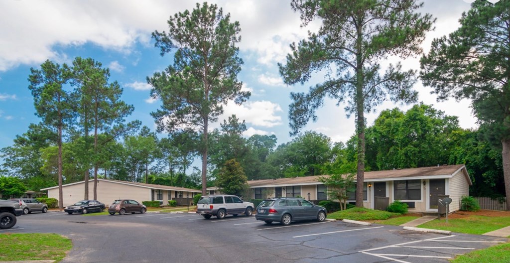 A parking lot with cars and a building in the background.