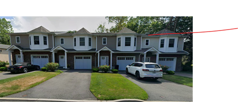 A white car is parked in front of a house.