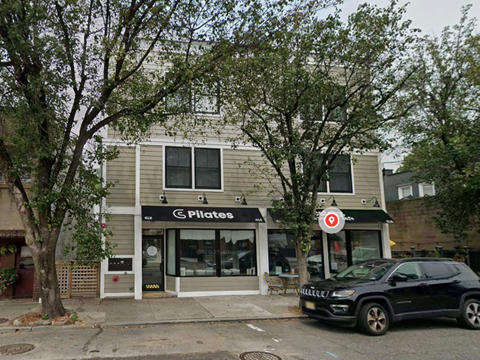 A Pilates studio is located in a building with a grey facade.