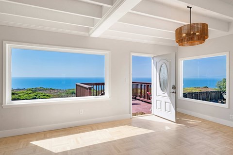 A room with a view of the ocean through the windows.