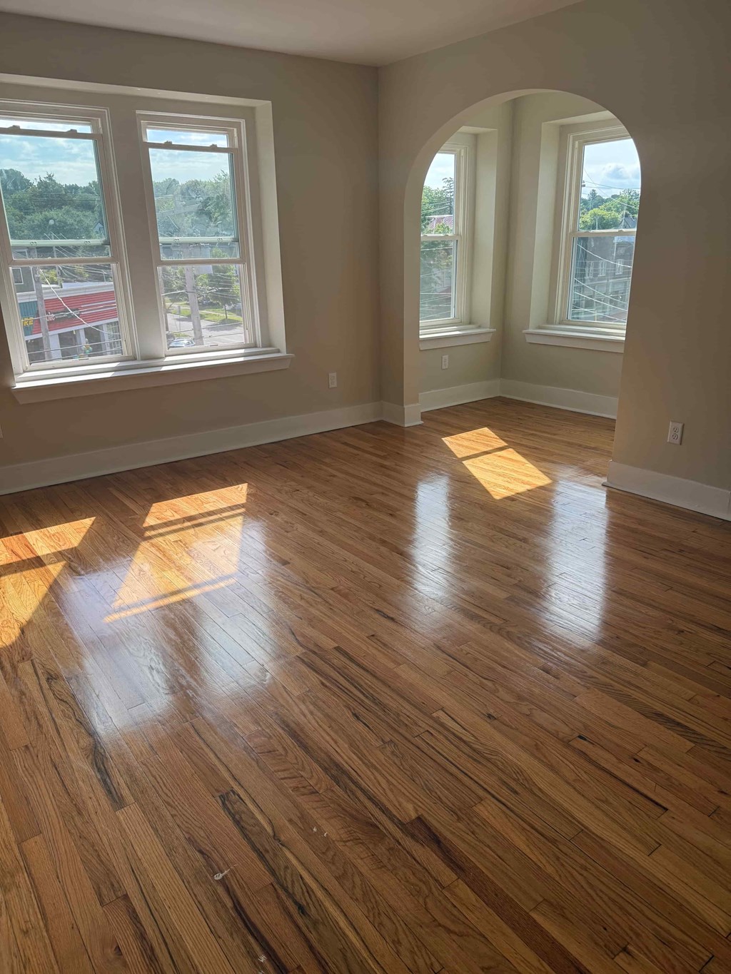 A room with wooden floors and large windows.