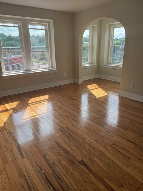 A room with wooden floors and large windows.