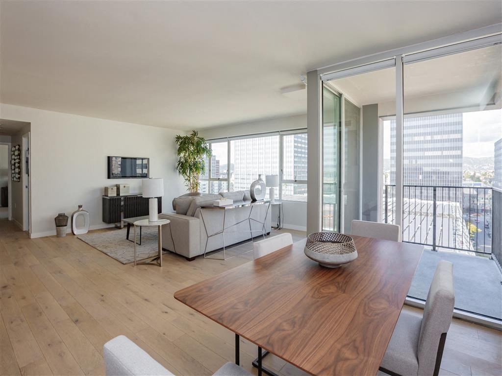 A modern living room with a wooden table and grey couch.