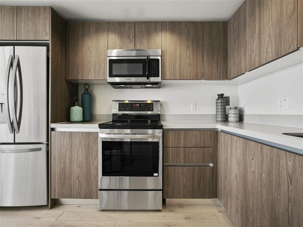 A modern kitchen with a stainless steel oven and microwave above the stove.
