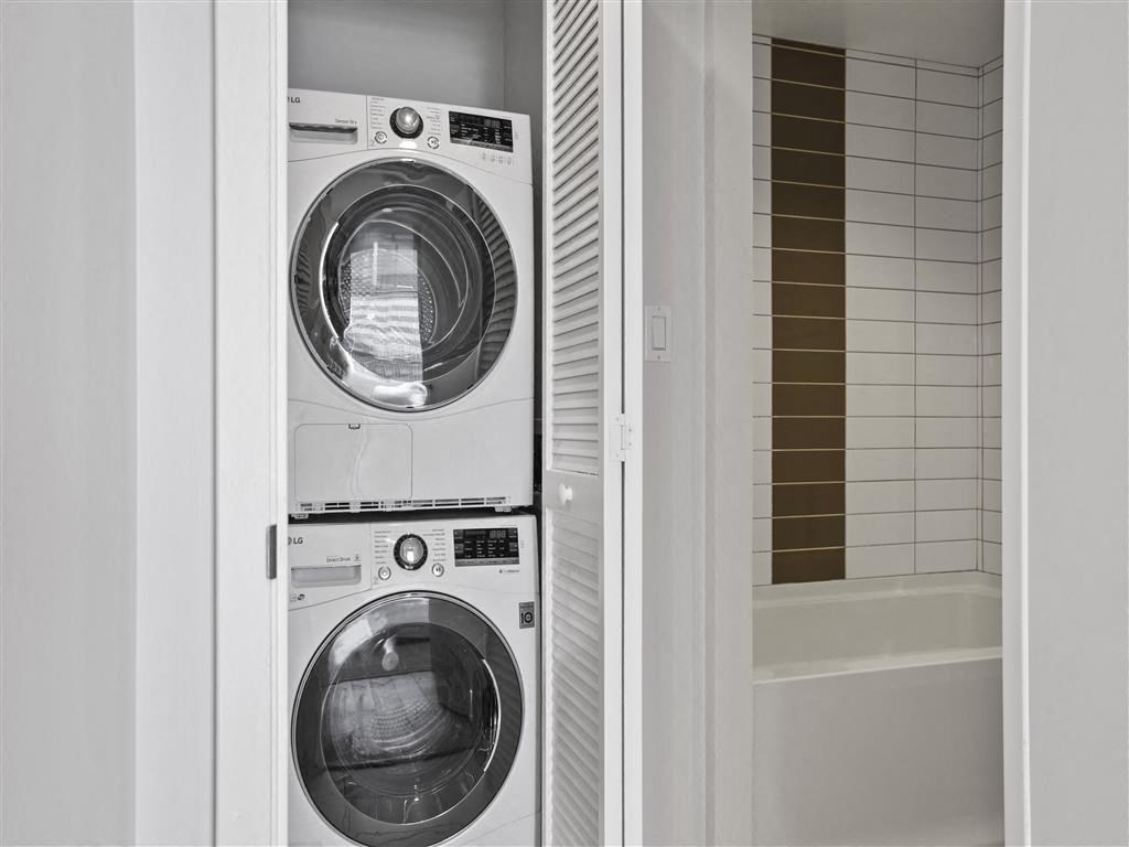 A white washing machine and dryer in a laundry room.
