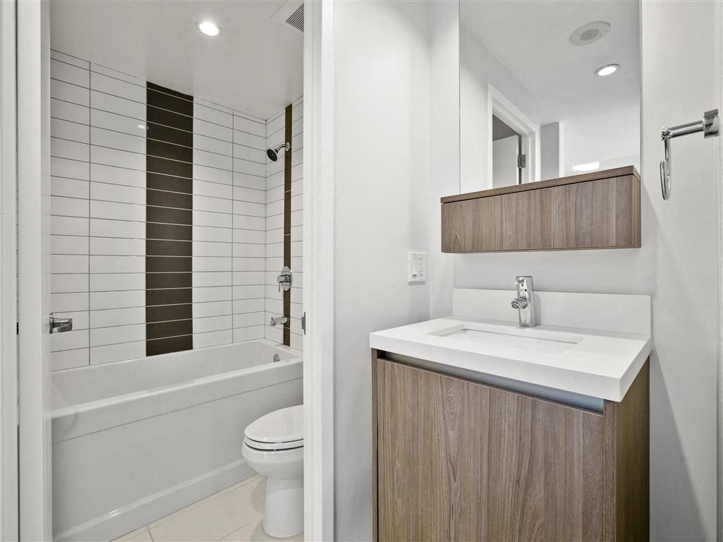 A white sink is on a wooden cabinet in a bathroom.