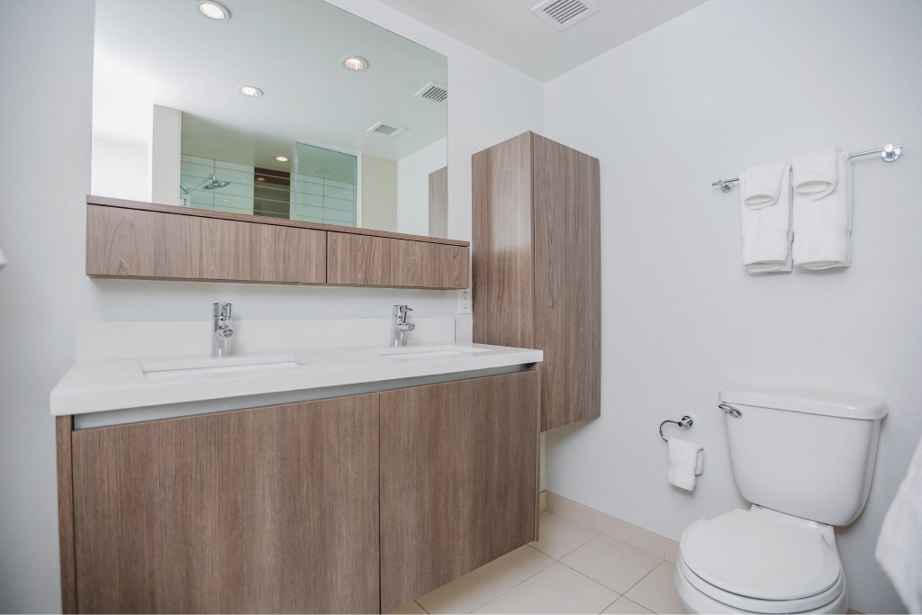 A white toilet sits next to a sink in a bathroom.
