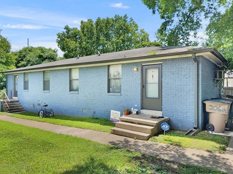 A blue house with a bicycle parked in front.