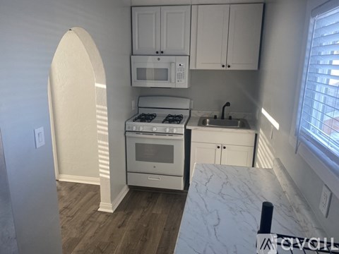 A kitchen with a white oven and sink.