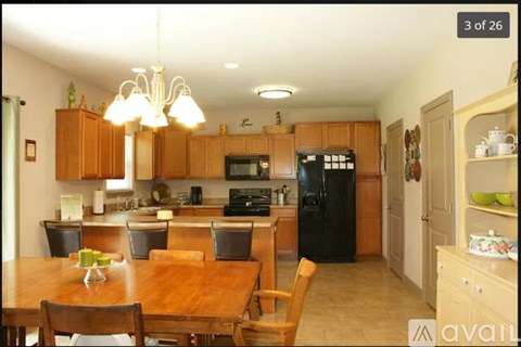 A kitchen with wooden cabinets and a black refrigerator.