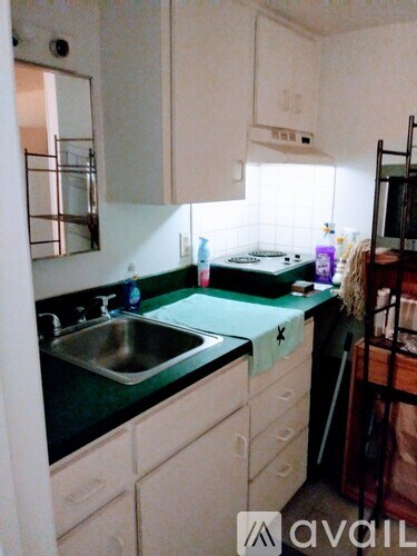 A kitchen with white cabinets and a green counter top.