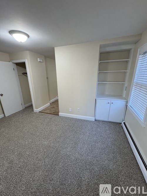 A room with a grey carpet and a white door.