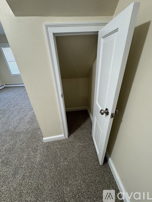 A white door is open to a small room.