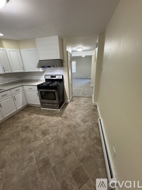 A kitchen with white cabinets and a black stove top oven.