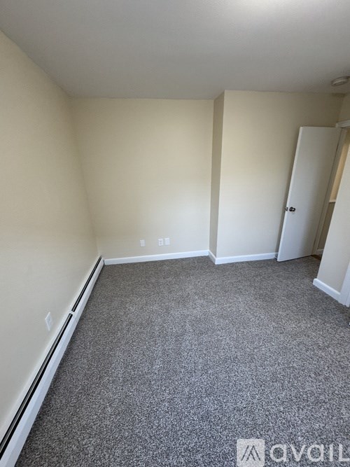 A room with a grey carpet and white walls.
