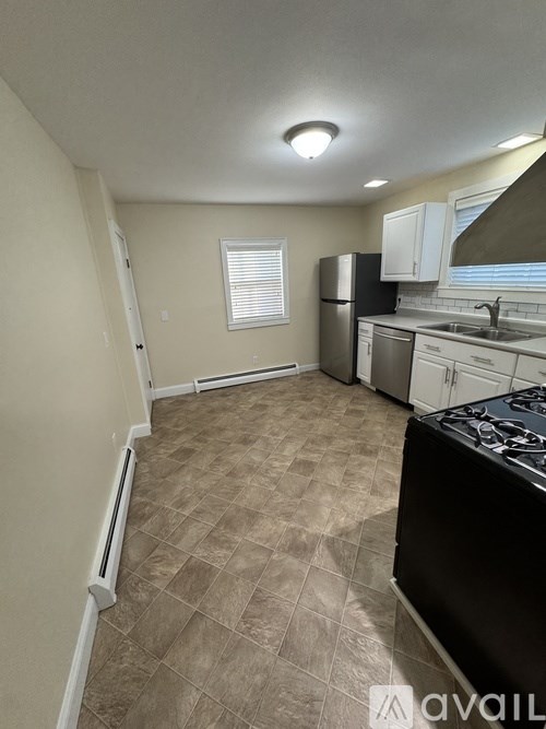 A kitchen with a black stove top oven and white cabinets.