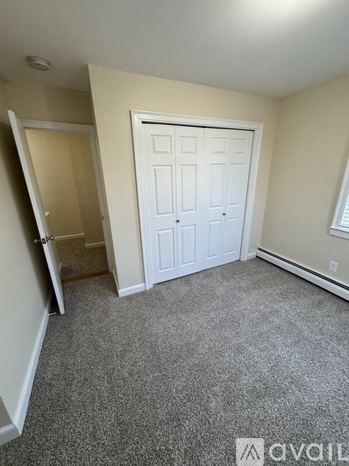 A room with a carpeted floor and a white door.
