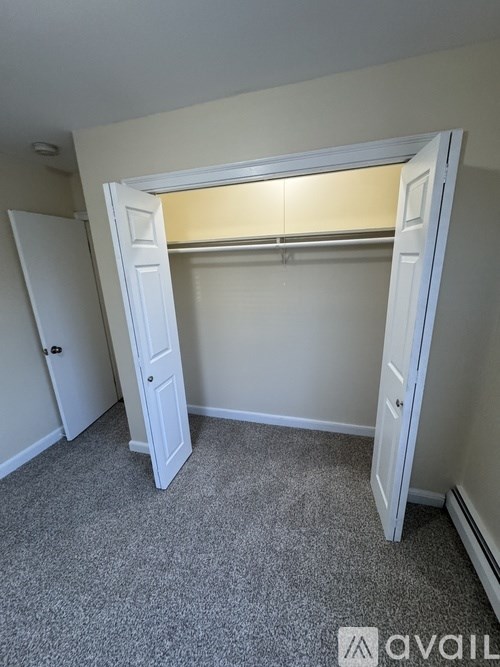 A room with a carpeted floor and a white door.