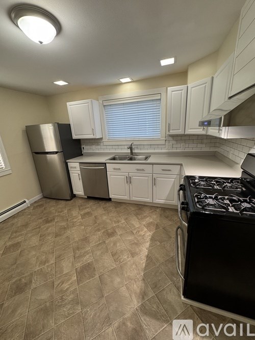 A kitchen with a black stove top oven and a black refrigerator.