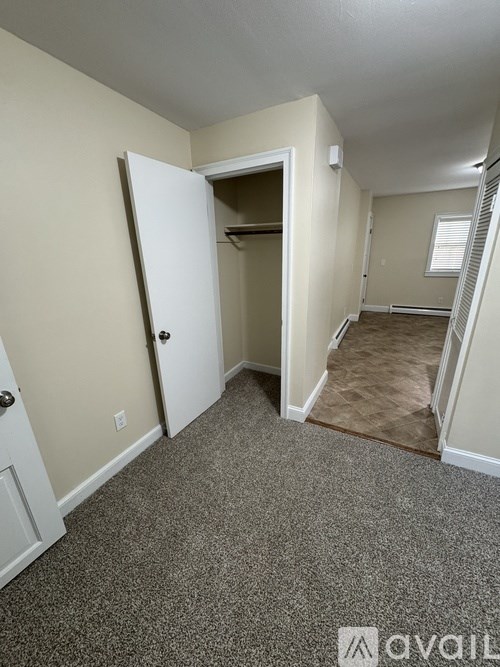 A room with a carpeted floor and a doorway leading to another room.