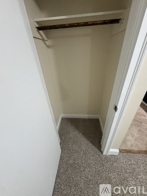 A hallway with a carpeted floor and a door on the right.