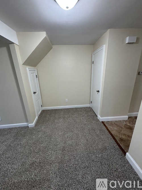 A room with a carpeted floor and a skylight.