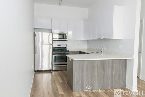 A kitchen with white cabinets and a wooden island.