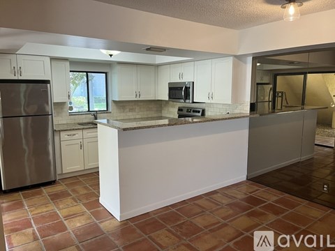 A kitchen with a refrigerator, microwave, and oven.