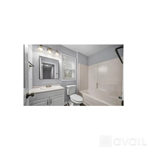 A bathroom with a toilet, sink, and bathtub.