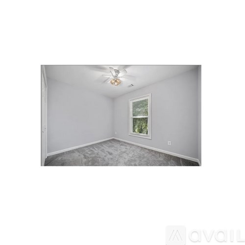 A room with a window and a ceiling fan.