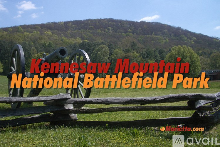 A cannon is in the foreground of a Kennesaw Mountain National Battlefield Park sign.