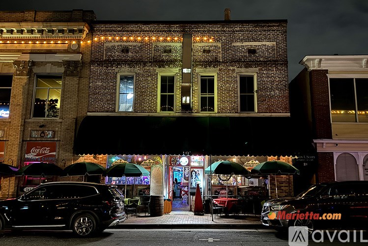 A black SUV is parked in front of a building with a Coca-Cola sign.