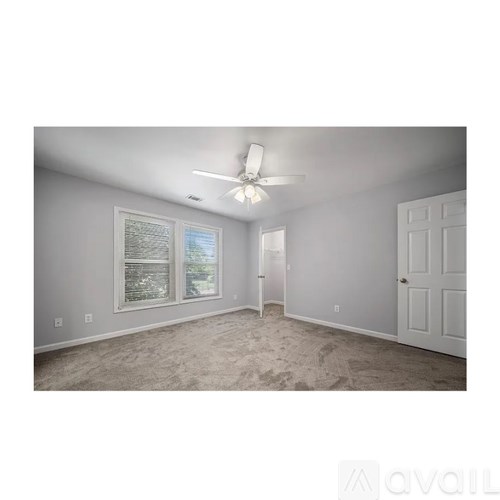 A room with a ceiling fan and a door.