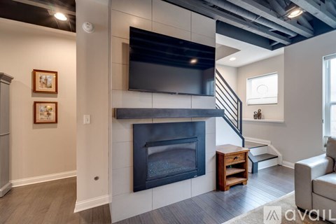 A modern living room with a fireplace and a television mounted above it.