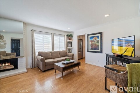 A living room with a fireplace, a couch, a coffee table, and a painting on the wall.