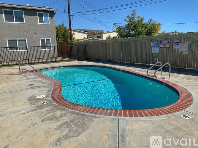 A small pool with a red border is surrounded by a concrete floor.