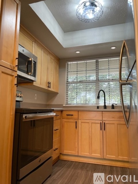 A kitchen with wooden cabinets and a stainless steel oven.