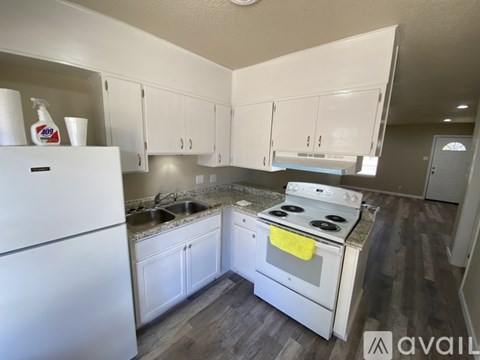 A kitchen with white appliances and cabinets.